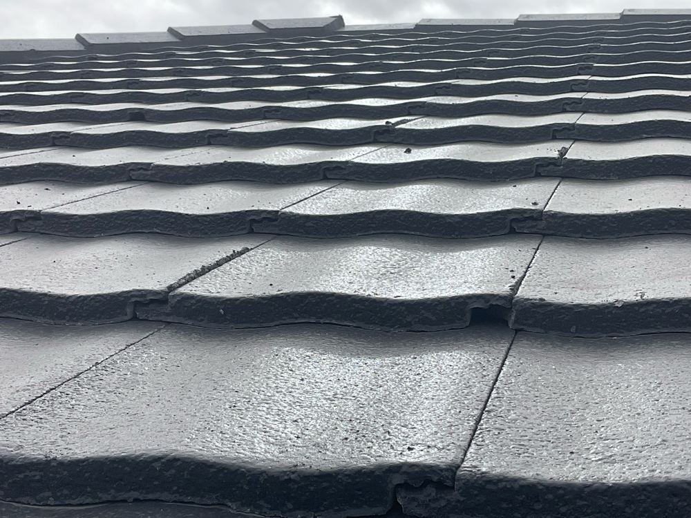 Broken underlap on a roof tile, weakening the seal between courses, found during a fixing inspection in Aintree