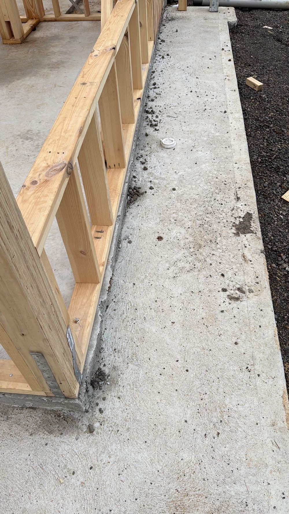 Concrete protruding beyond the timber wall, leaving the cavity below its minimum width, found during a frame inspection in Aintree