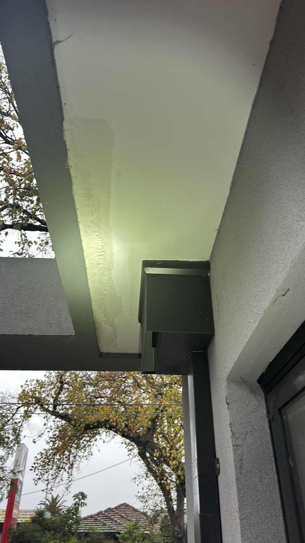 Balcony drain plumbed straight into the downpipe, with leak stains on the eaves below, found during a defect investigation in Maidstone