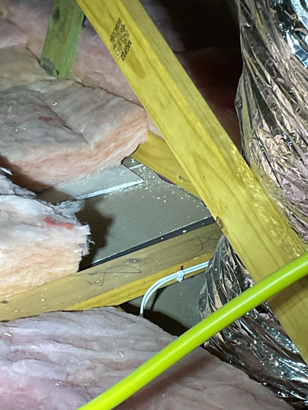 Gaps in the ceiling insulation where batts have been pushed aside, found during a pre-handover inspection in Aintree